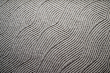 Simple graphic wave patterns raked into a background in the white sand of a Japanese Zen garden - Powered by Adobe