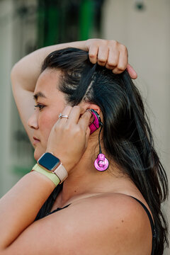Woman putting on hearing device