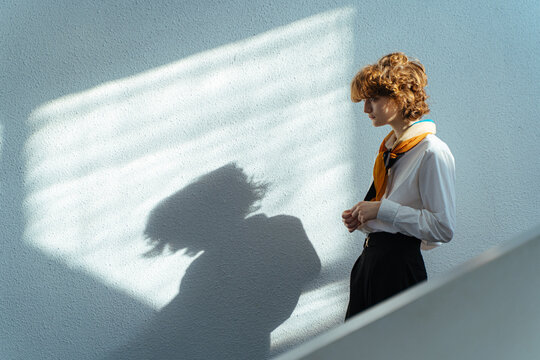 cute girl in shirt and tie stands on the stairs