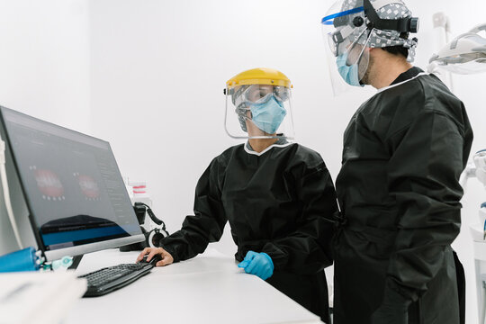 Dentists dressed in safety and epidemic protection clothing inside the dental office.