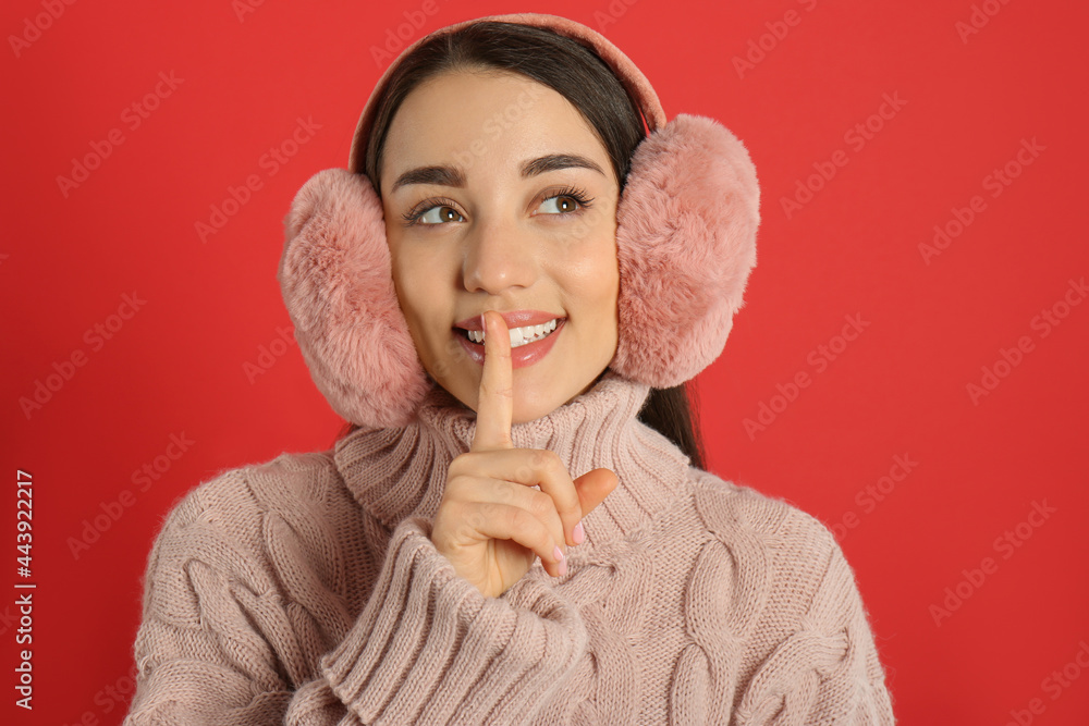 Canvas Prints Beautiful young woman wearing earmuffs on red background