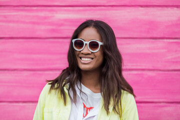 Happy Fijian woman resting near pink wall
