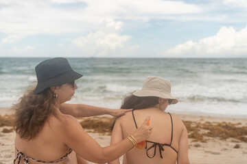 Girls applying sunscreen on the beach