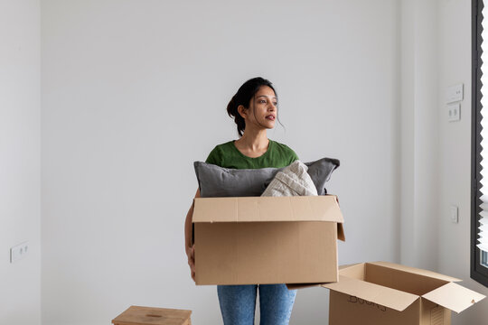 Woman carrying a moving box at home