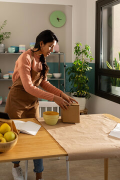 Young woman packing at workplace