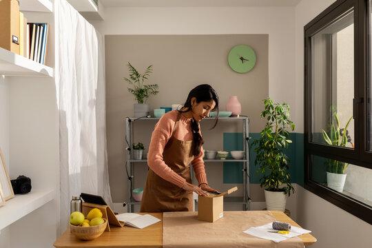 Woman packing an ecological bowl at online store