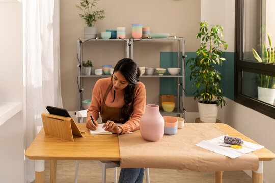Worker preparing online order of ecological tableware to send it