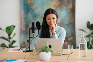 Female radio host in studio with laptop and microphone