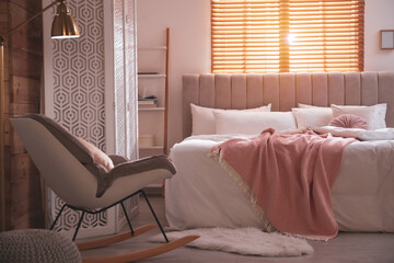 Cozy bed with soft linens in light room