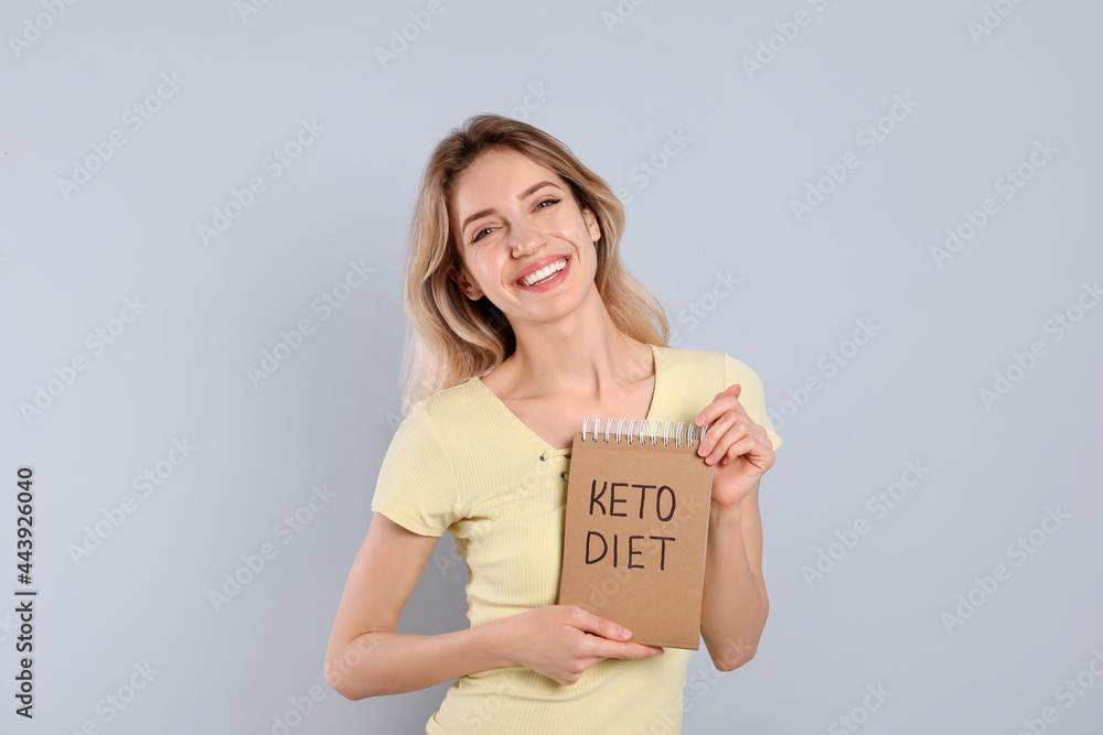 Canvas Prints Woman holding notebook with phrase Keto Diet on grey background