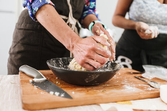 Hands rolling dough