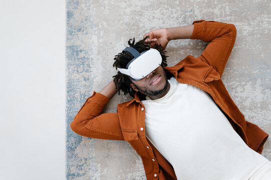 Relaxed man in VR glasses experiencing cyberspace