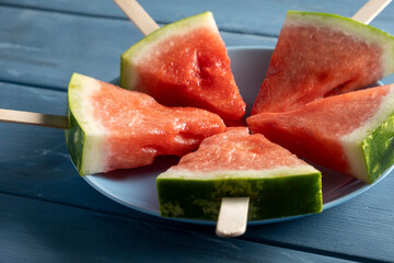 Sliced watermelon. Slices on rustic blue table. Copy space.