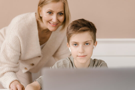 Cheerful mother and son doing homework together