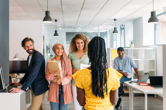 Smiling multiracial colleagues walking in corridor of contemporary office