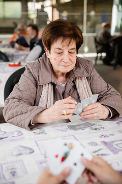 Elderly woman concentrated playing cards