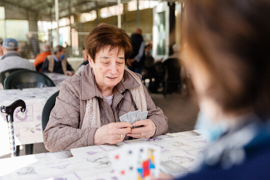 Elderly woman enjoying playing cards