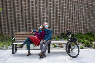 masked couple on city bench