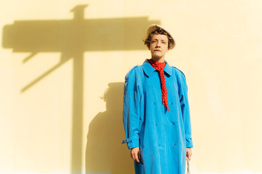 Vintage female standing near yellow wall
