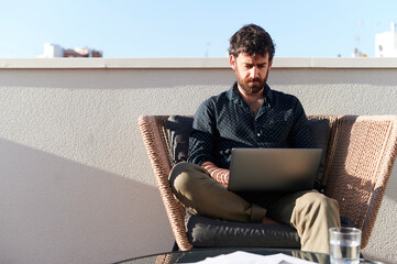 Man working remotely from home on his patio 