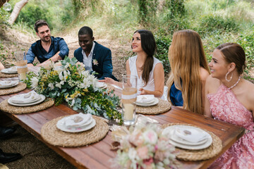 Newlyweds and guests celebrating wedding in nature