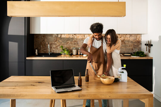 Young couple enjoying cooking together at cool kitchen