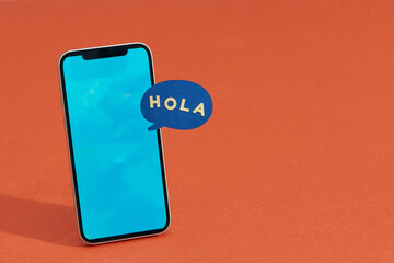 Pop-up dialog box on the mobile phone with text "Hola"