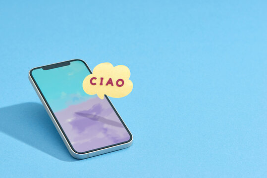 Smartphone with Ciao in speech bubble on color background