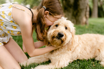 tween girl snuggling her adorable  dog
