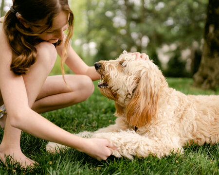 girl petting her puppy 