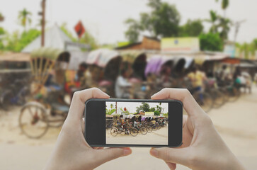 Taking photo on smart phone concept.Cycle rickshaw riding on the street of Old Delhi, India