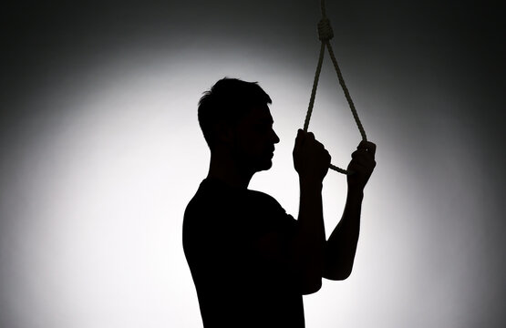 Silhouette of man with rope noose on light background