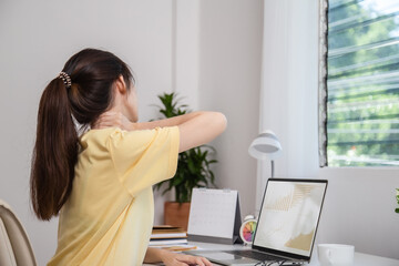 Office syndrome concept. Woman using hand to massage her neck feeling pain in neck after working on...