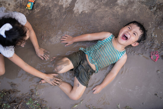 Asian boy playing mud
