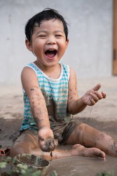 Asian boy playing mud