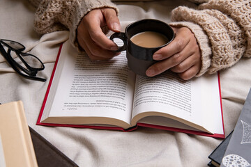 man reading a book holding coffee