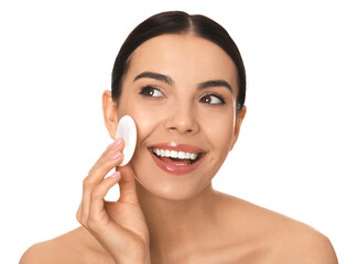 Beautiful young woman applying face powder with puff applicator on white background