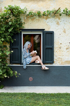 Woman sitting outdoor and reading a book