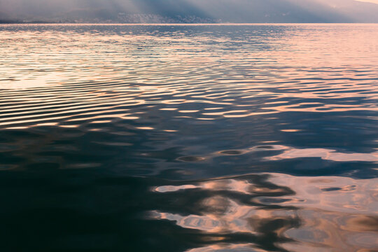 Sunset reflection on calm sea water.
