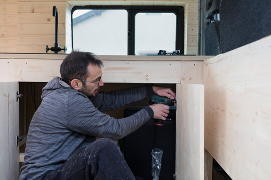 Man building kitchen in Camper Van