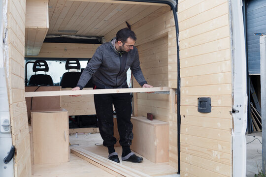 Man Working on Transforming Van into Camper