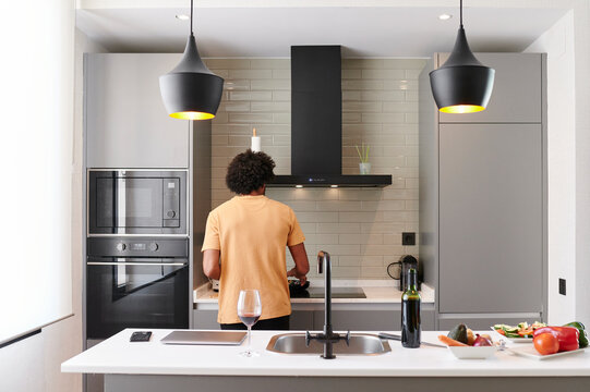 Young man cooking dinner on a stove