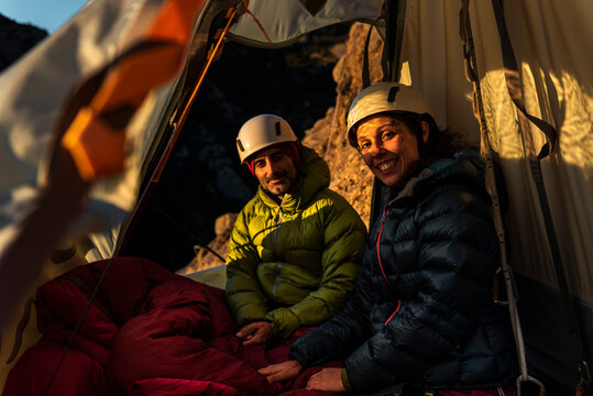 Climbers resting inside a wall portaledge at mountain