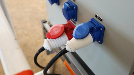 Electrical plug with wires on the generator. The blue and red dual power plugs are connected on the...