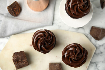 Flat lay composition with delicious chocolate cupcakes on white marble table