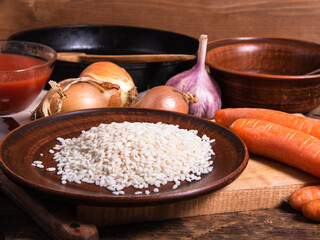 Ingredients for making vegetarian risotto - rice in a plate and vegetables