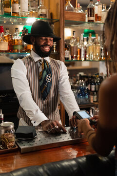 Cheerful bartender waiting for client to enter pin code