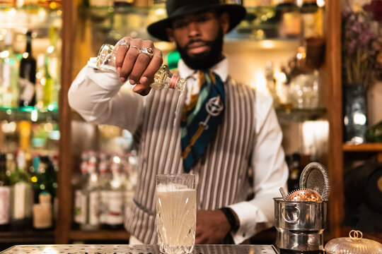 Stylish barman preparing alcoholic cocktail in bar