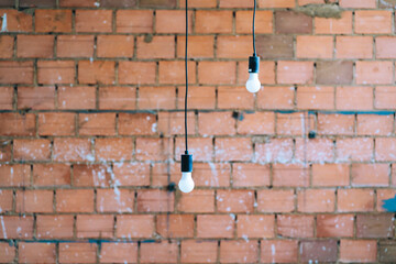 Light bulbs hanging on a brick wall
