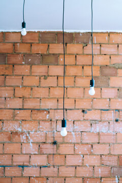 Light bulbs hanging on a brick wall
